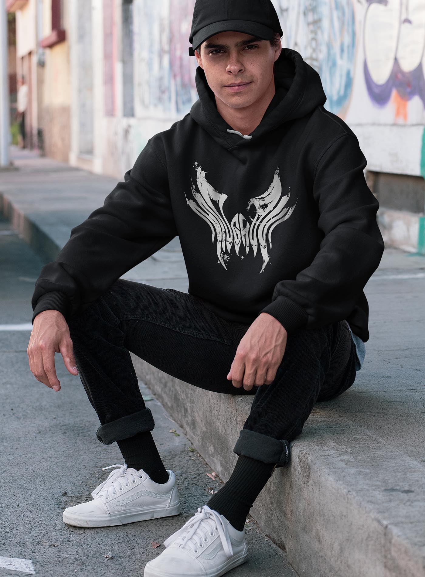 man modeling a Black unisex hoodie featuring a front print of the black Mr. Splatter Moghoul logo by Sasha Sidorovich.
