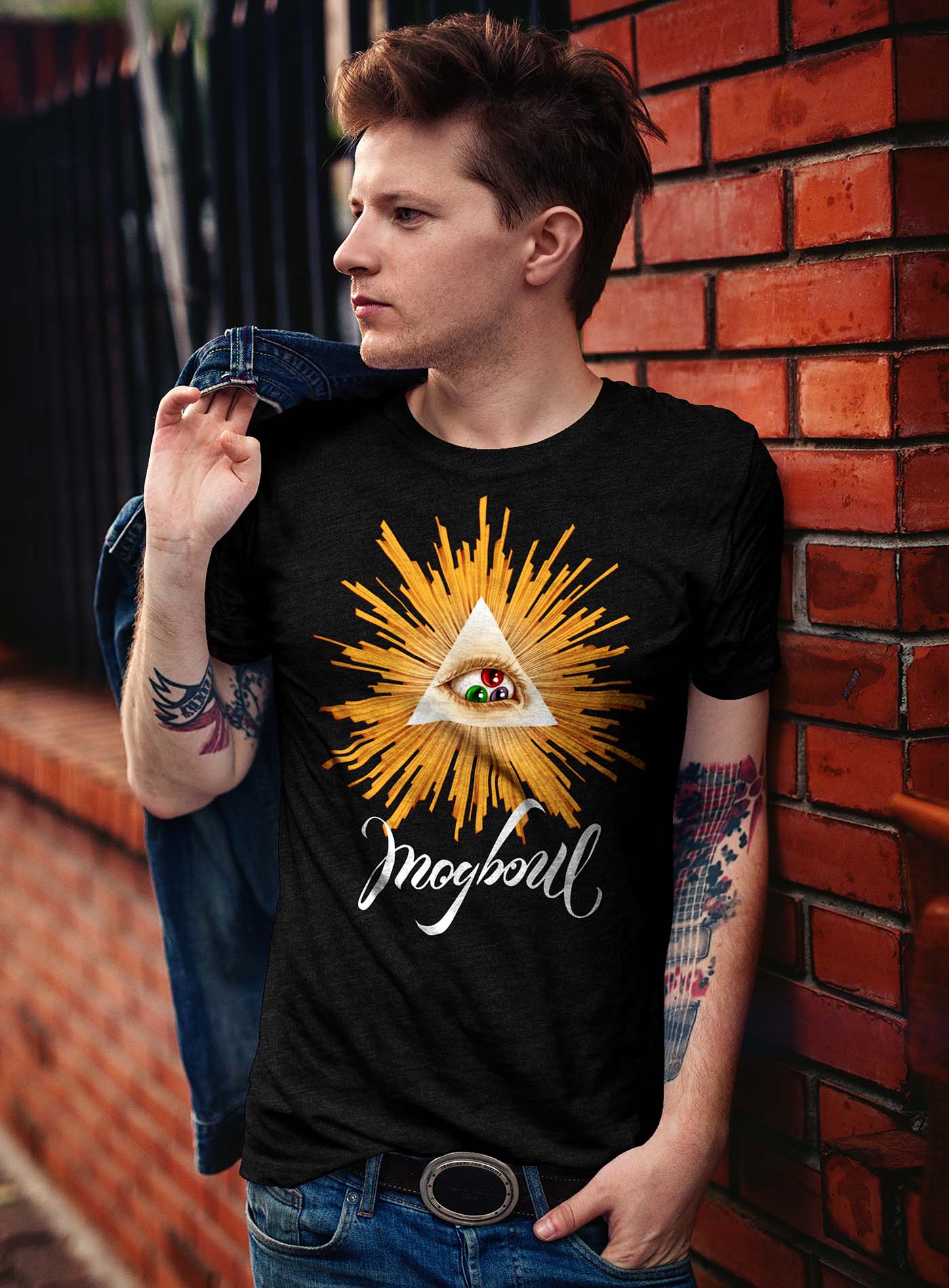 man modeling a Heather black unisex t-shirt featuring a front print of a reinterpretation of the Horus pyramid and Moghoul ambigram logo by G.M. Meave.