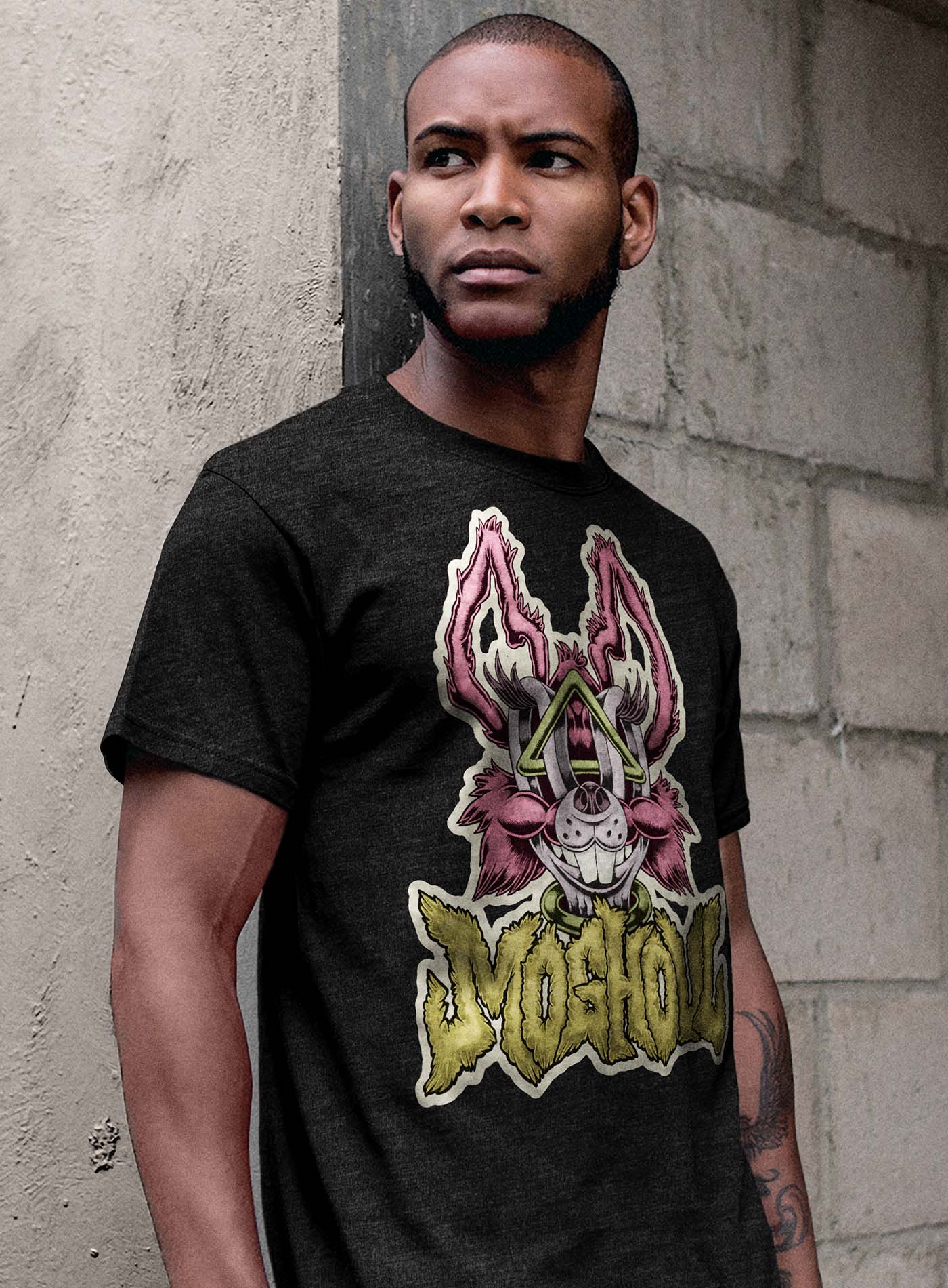 man modeling a Heather black unisex t-shirt featuring a front print of a dog and the Moghoul logo rendered in urban art style by Jason Hankins aka Jazmo.