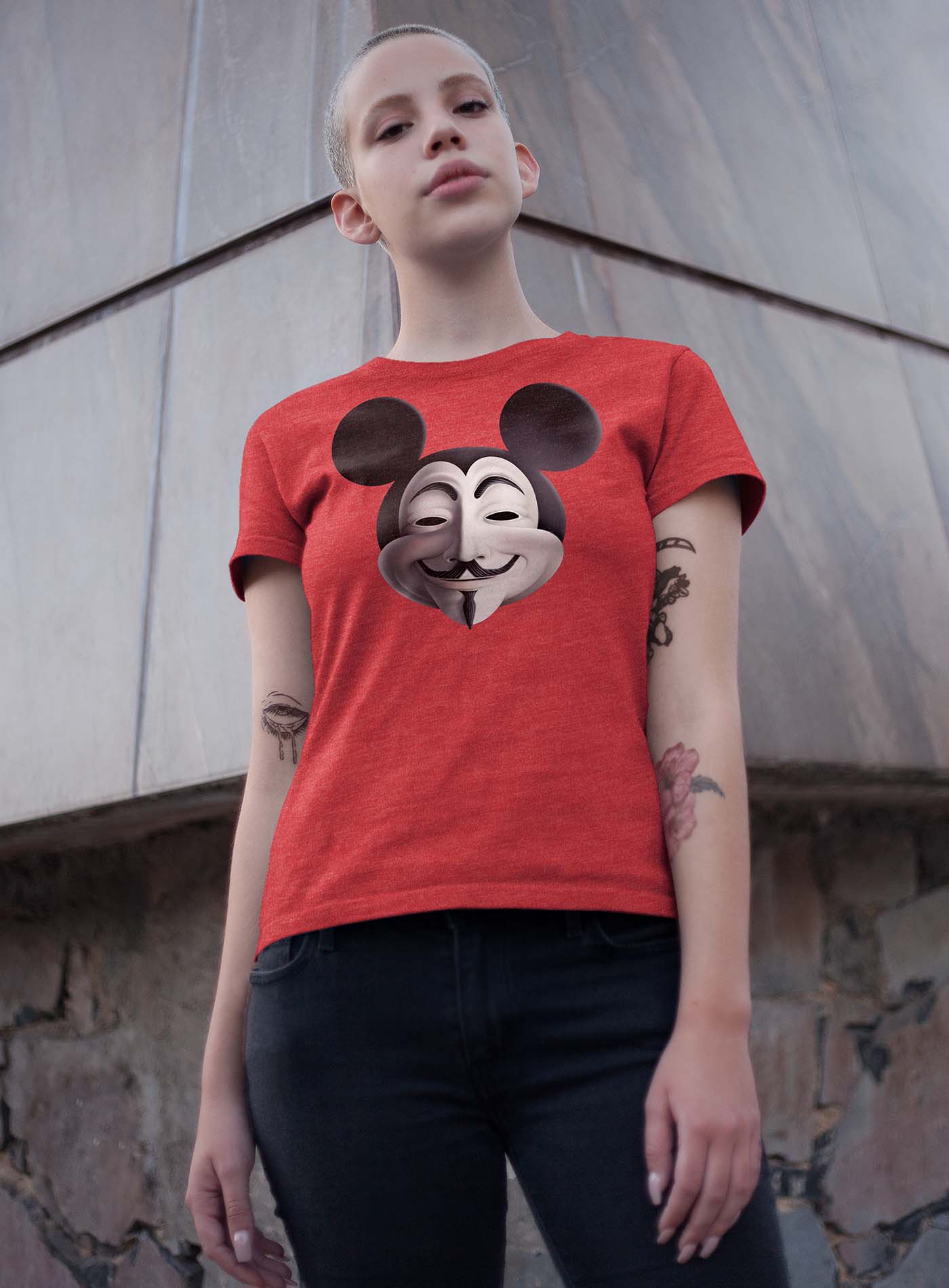man modeling a heather grey unisex t-shirt featuring a front print fusing Mickey Mouse and Guy Fawkes.