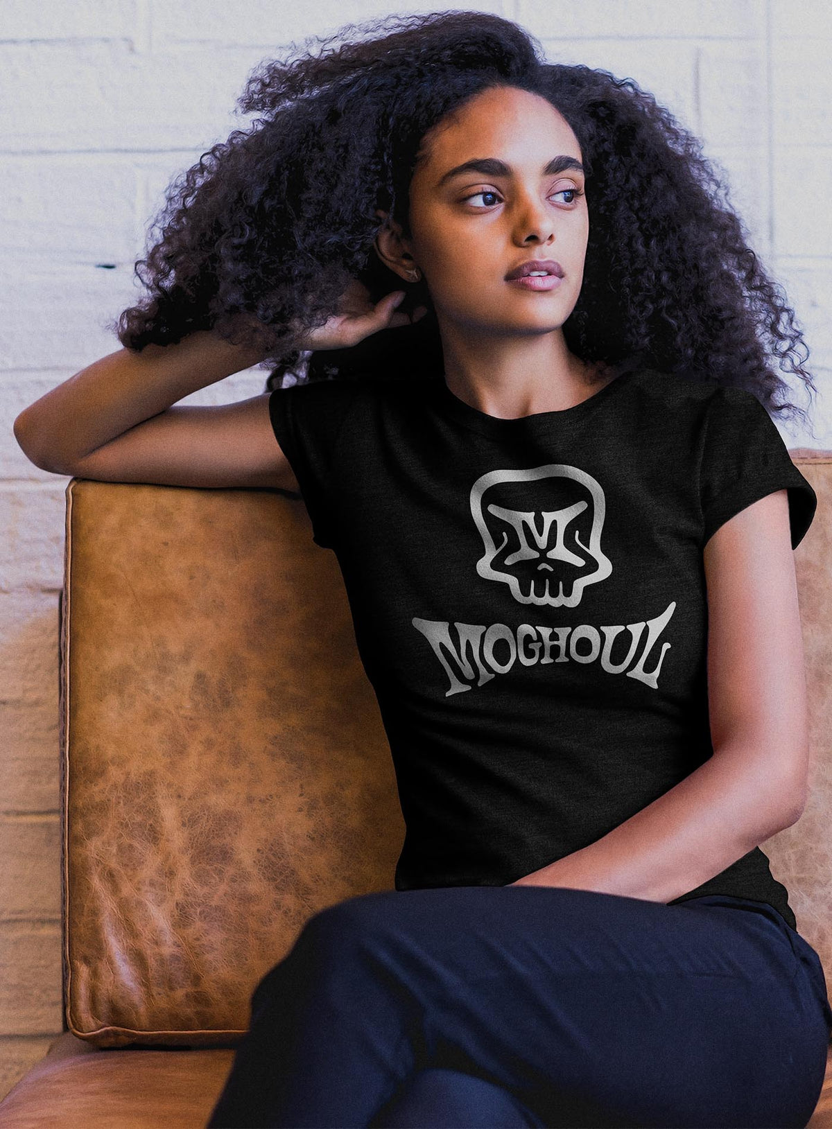 Woman modeling a heather black unisex t-shirt featuring a front print of the Mr. M Moghoul logo by G.M. Meave.