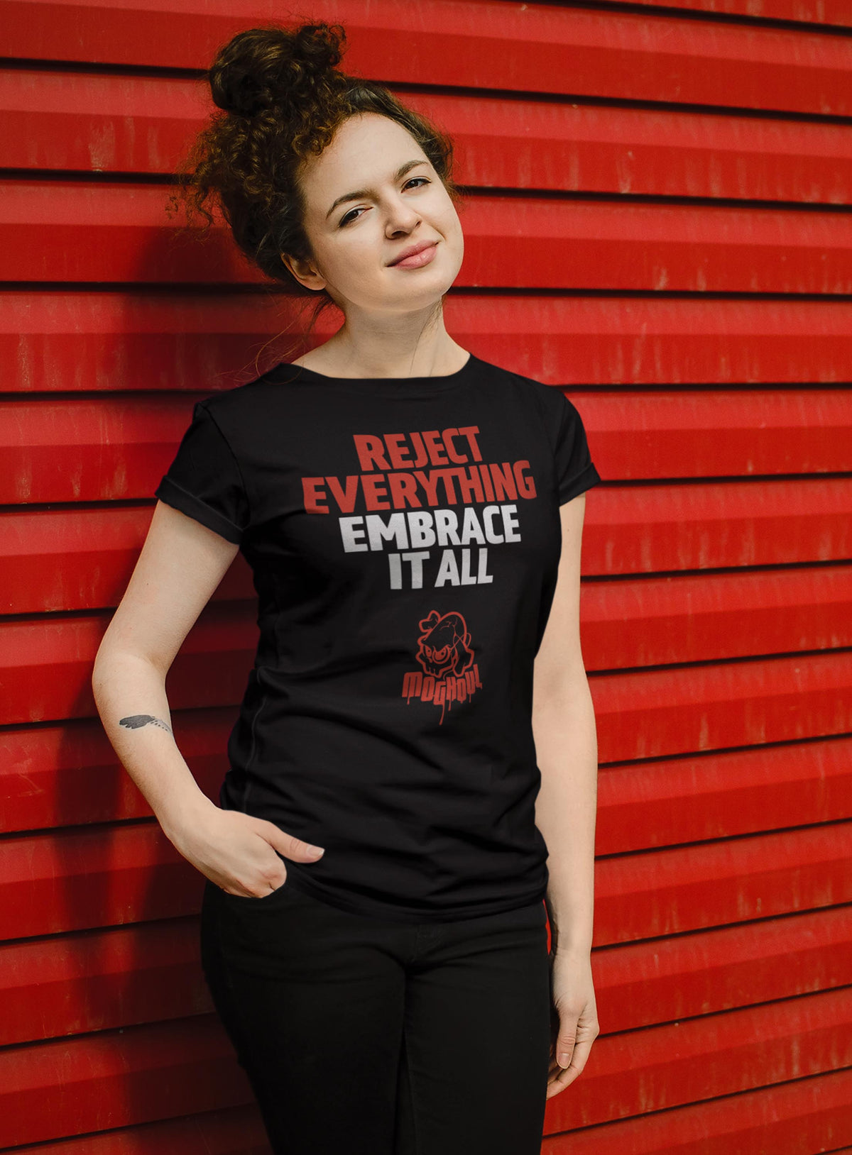 Female modeling a black unisex t-shirt featuring the paradoxical phrase &quot;Reject everything, embrace it all&quot; and the moghoul logo.