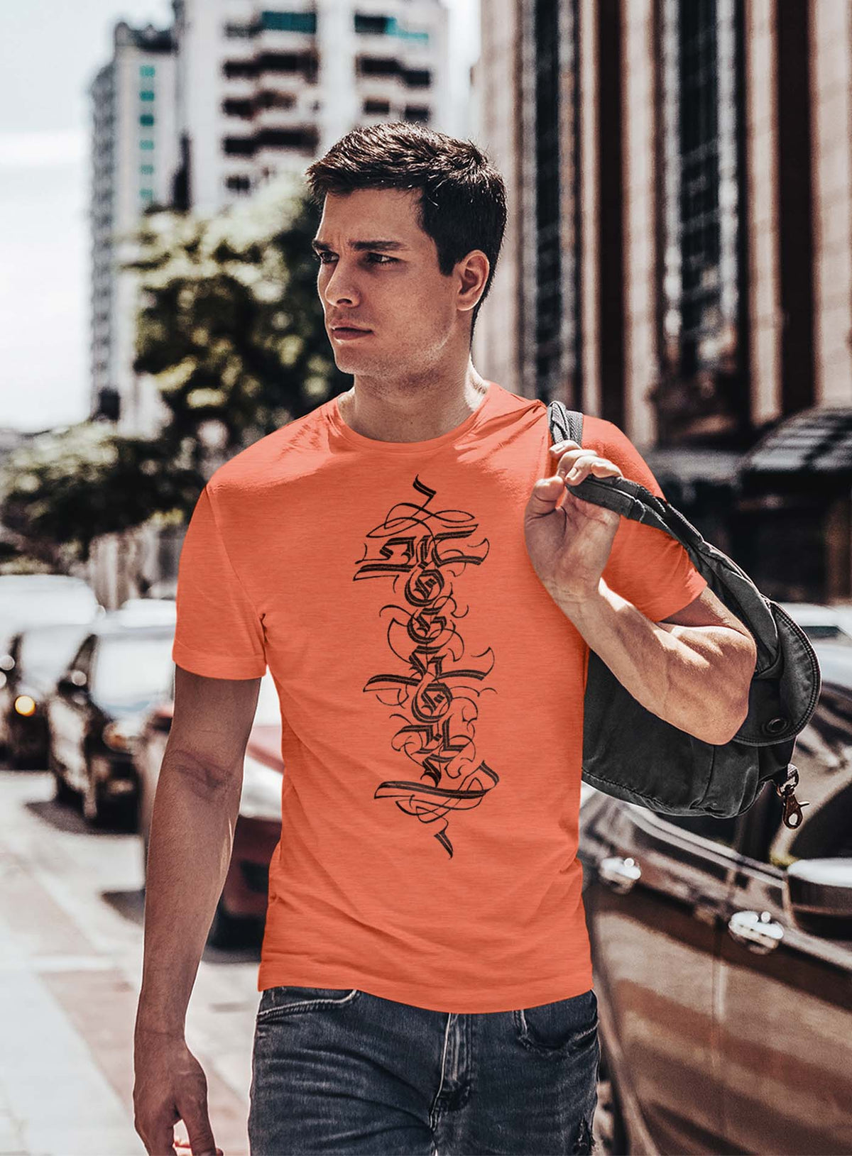 man modeling a Heather orange unisex t-shirt featuring a front print of a white Moghoul straight-up-gothic logo by Mexican typographer G.M. Meave.