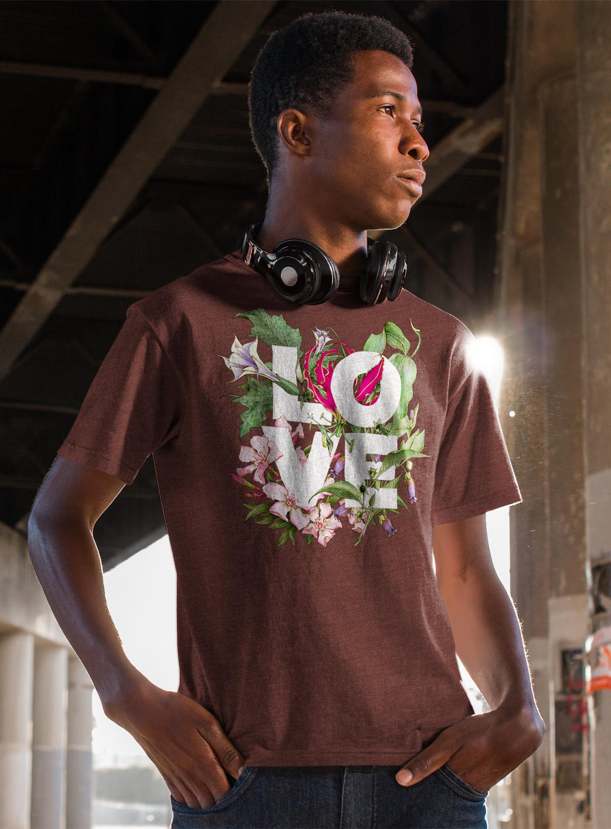 Man modeling a brown unisex t-shirt featuring the word LOVE surrounded by poisonous flowers such as oleander, fire lily, belladonna and toloache.