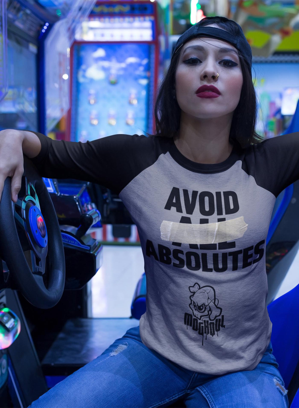 Woman modeling a Heather grey unisex reglan t-shirt featuring the paradoxical phrase &quot;avoid all absolutes&quot; and the moghoul logo.