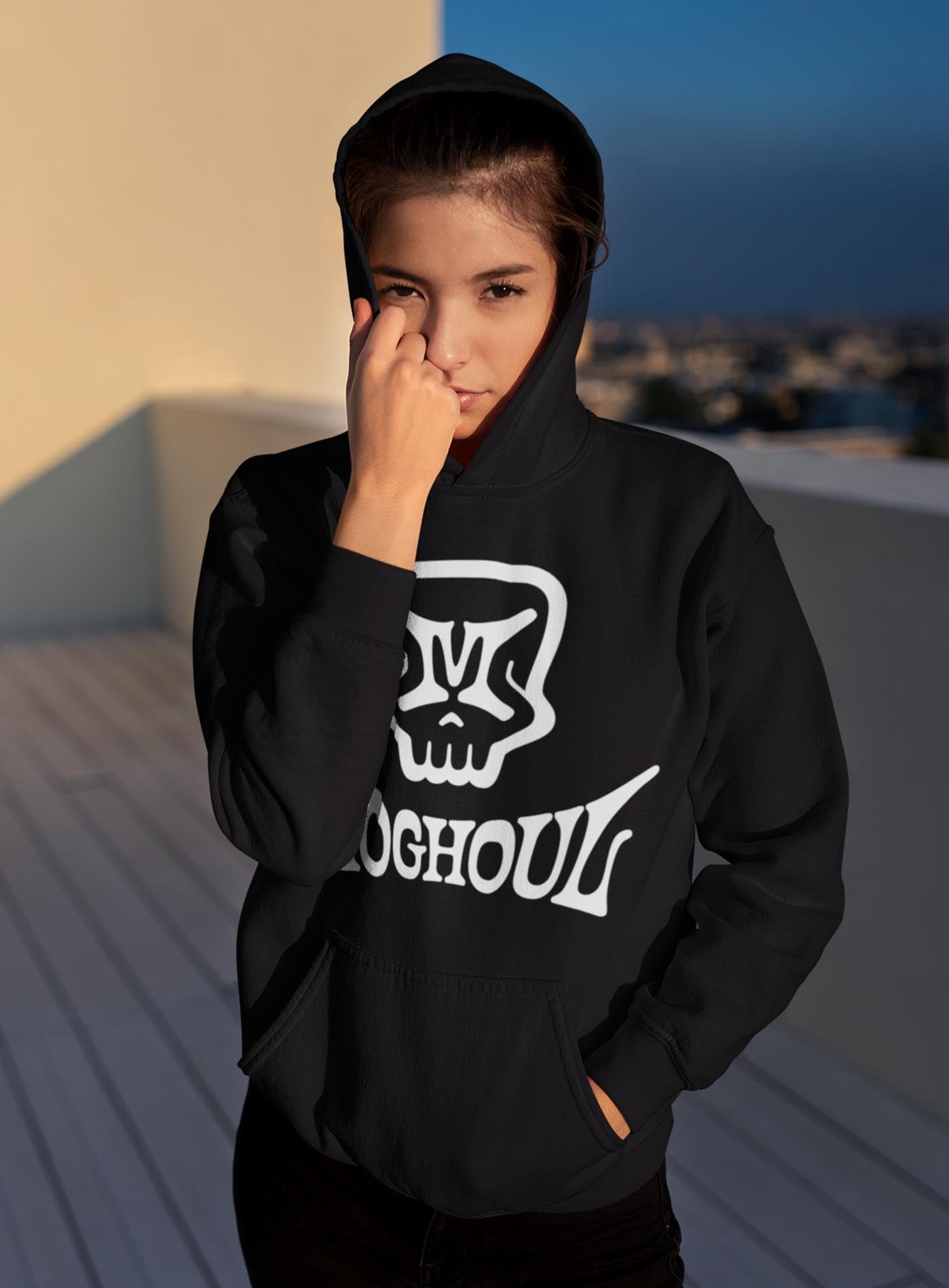 Female modeling a Black unisex hoodie featuring a front print of the Mr. M Moghoul logo by G.M. Meave.