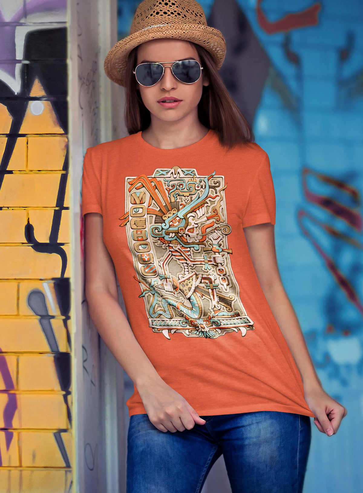 Woman modeling a Heather orange unisex t-shirt featuring a front print of the Aztec god Tezcatlipoca illustrated by G.M. Meave.