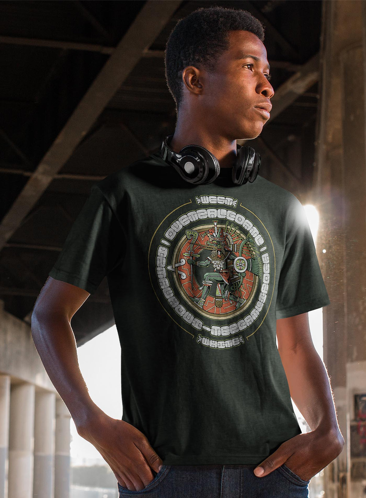 Man modeling a Heather green unisex t-shirt featuring a front print of the toltec-aztec god Tezcatlipoca also known as Quetzalcoatl. Reinterpretation by Mexican illustrator G.M. Meave.