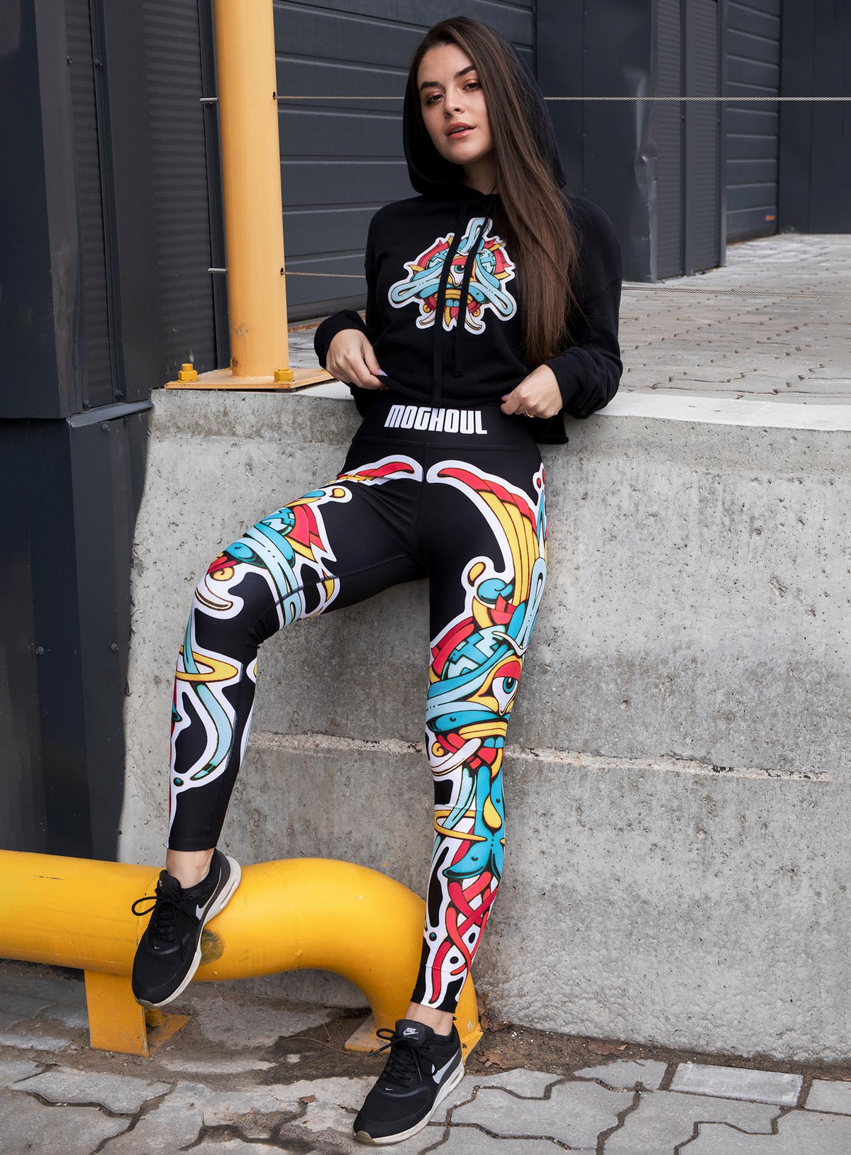 Woman modeling a Black woman&#39;s cropped hoodie and All over dye sublimation leggings featuring a print of the Toltec-Aztec goddess of grass illustrated by G.M. Meave