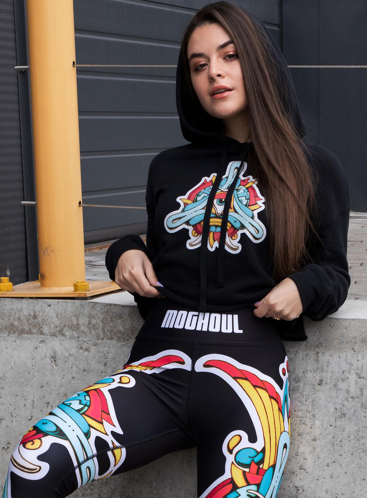 Woman modeling a Black woman&#39;s cropped hoodie and All over dye sublimation leggings featuring a print of the Toltec-Aztec goddess of grass illustrated by G.M. Meave