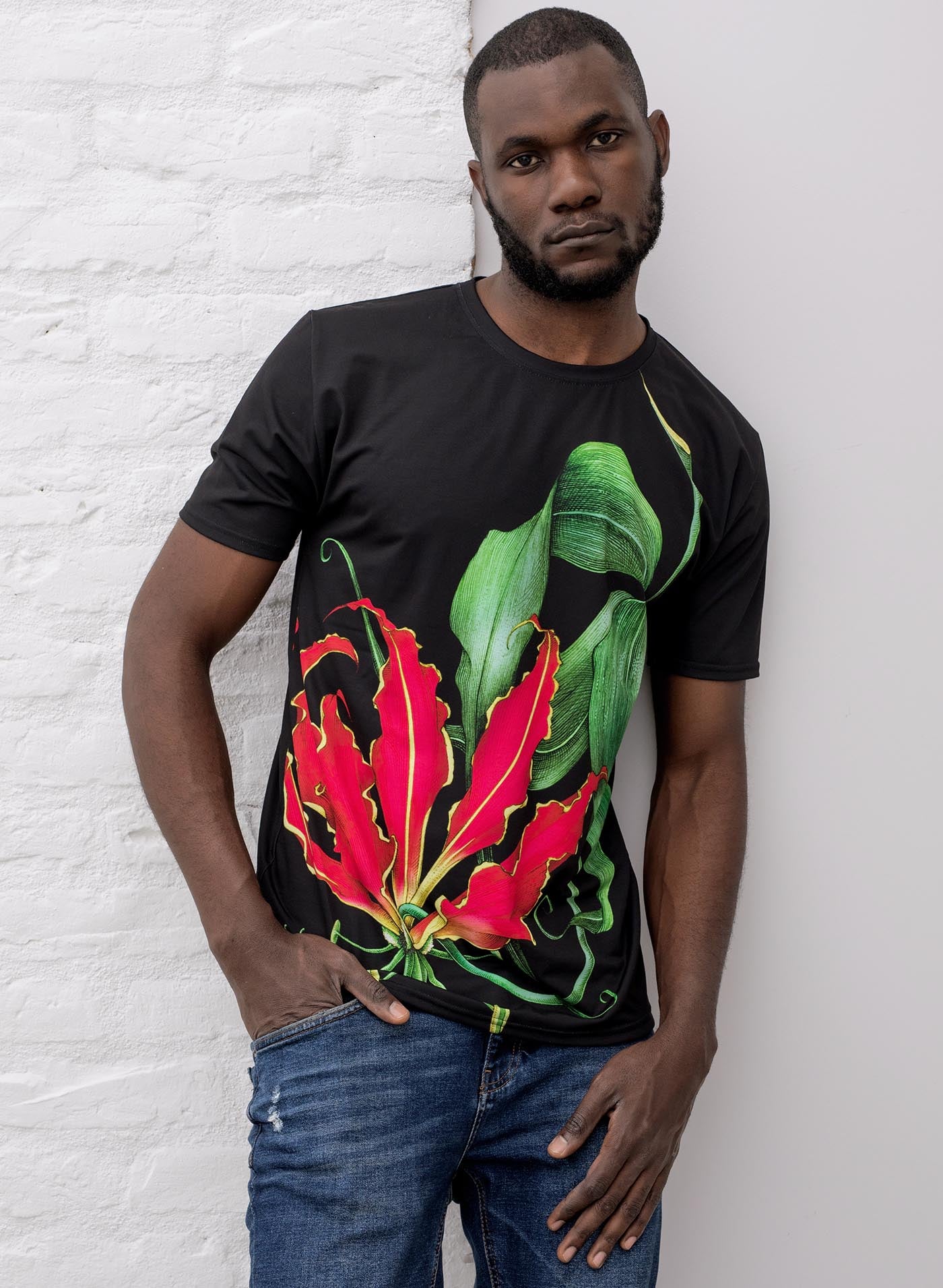 Man modeling an All over dye sublimation t-shirt featuring the poisonous flower Fire Lily. Illustrated by G.M. Meave.