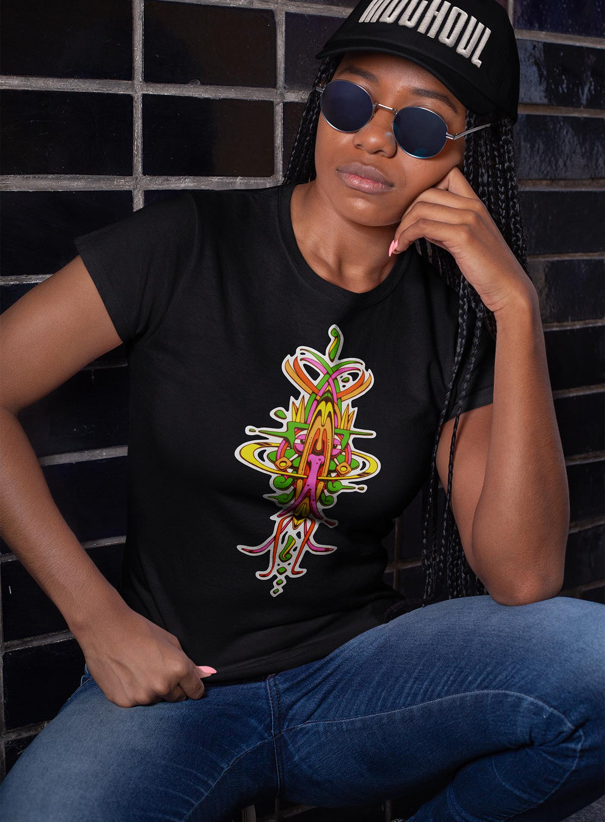 Woman modeling a heather black woman&#39;s t-shirt featuring a front print of the Toltec-Aztec hummingbird deity illustrated by G.M. Meave.