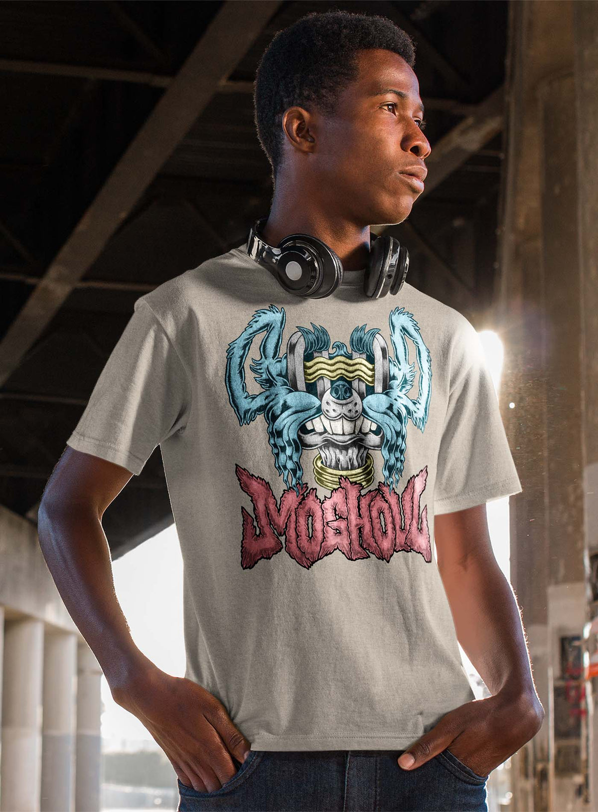 man modeling a Heather beige unisex t-shirt featuring a front print of a dog and the Moghoul logo rendered in urban art style by Jason Hankins aka Jazmo.