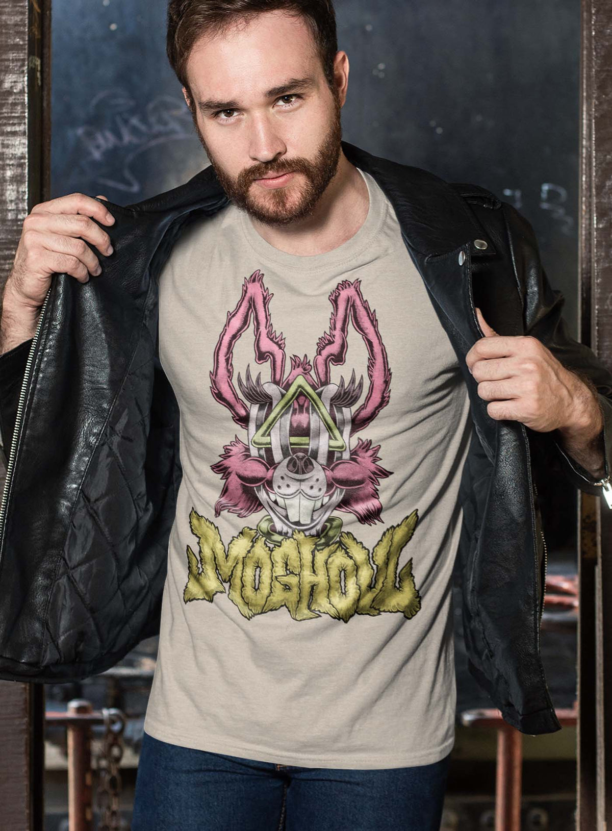 Man modeling a Heather beige unisex t-shirt featuring a front print of a dog and the Moghoul logo rendered in urban art style by Jason Hankins aka Jazmo.