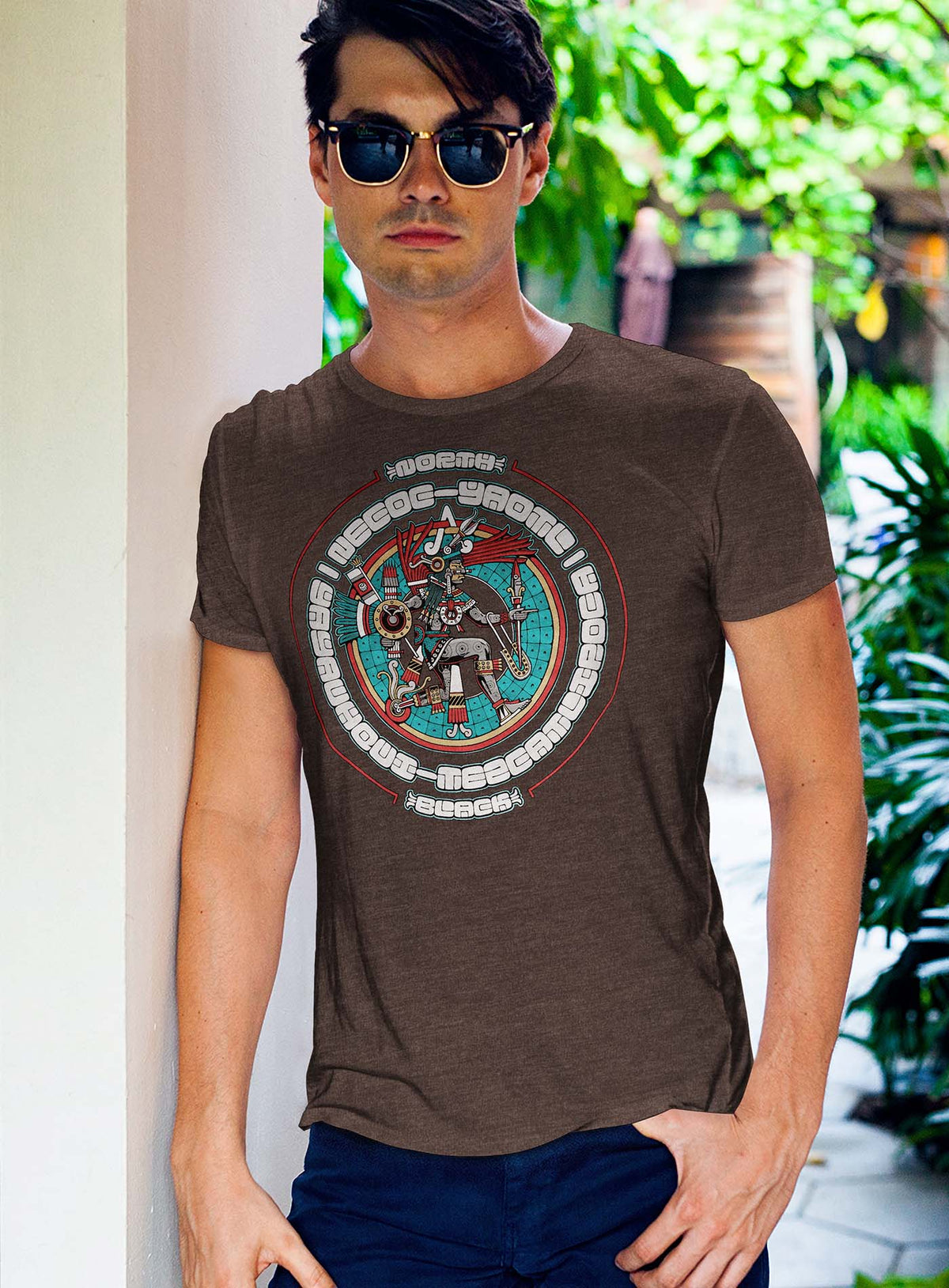 Man modeling a Heather brown unisex t-shirt featuring a front print of the toltec-aztec god Yayauhqui-Tezcatlipoca also known as Necoc-yaotl. Reinterpretation by Mexican illustrator G.M. Meave.
