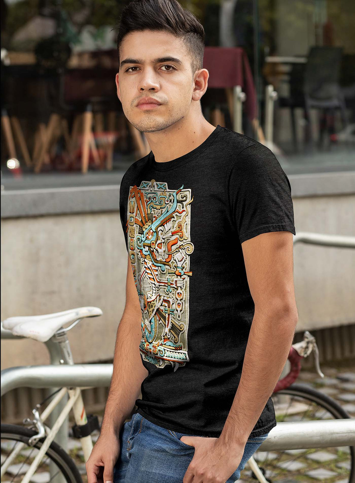 man modeling a Heather black unisex t-shirt featuring a front print of the Aztec god Tezcatlipoca illustrated by G.M. Meave.