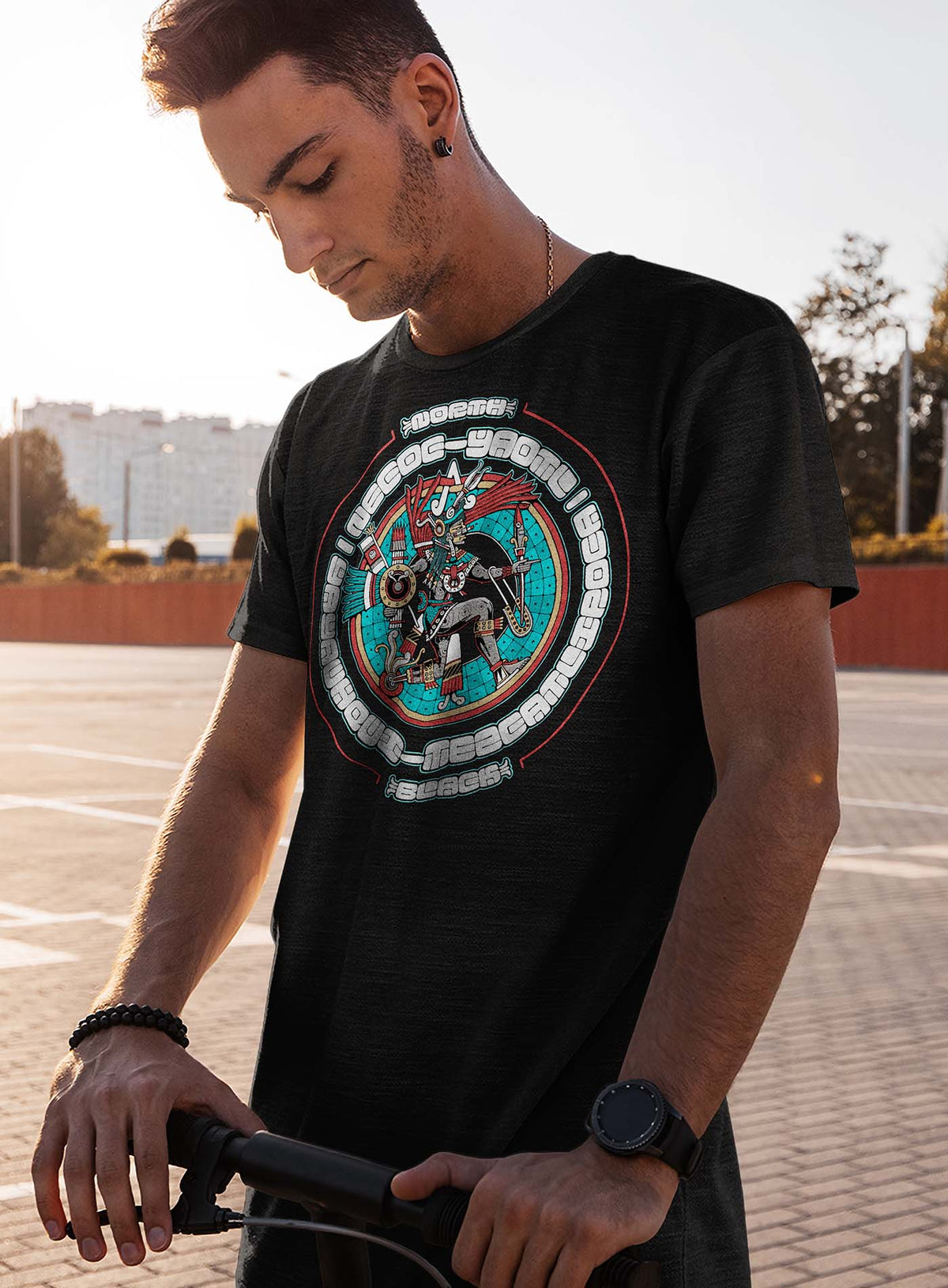 man modeling a Heather black unisex t-shirt featuring a front print of the toltec-aztec god Yayauhqui-Tezcatlipoca also known as Necoc-yaotl. Reinterpretation by Mexican illustrator G.M. Meave.