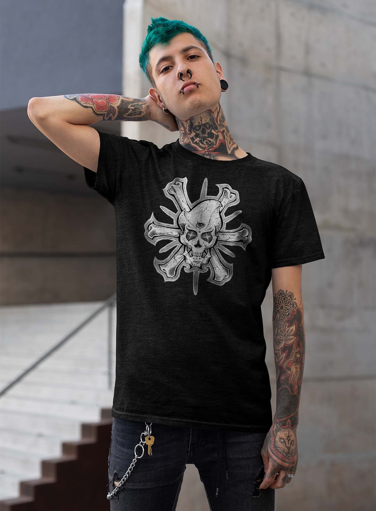 Man modeling a heather black unisex t-shirt featuring a front print of a three-bone alien Jolly Roger pirate illustration by G.M. Meave.