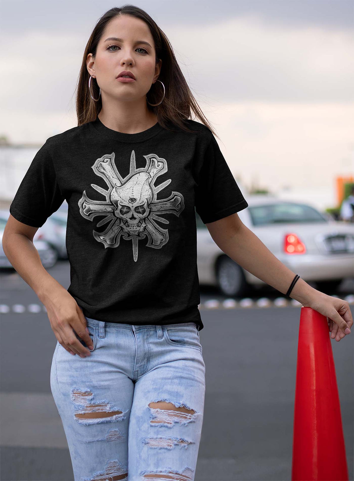 Woman modeling a heather black unisex t-shirt featuring a front print of a three-bone alien Jolly Roger pirate illustration by G.M. Meave.
