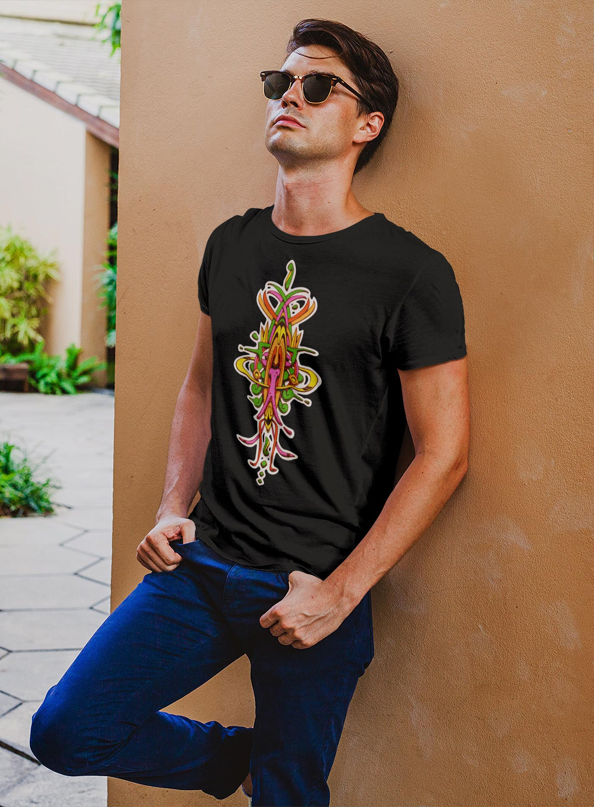 Man modeling a Heather black unisex t-shirt featuring a front print of the Toltec-Aztec hummingbird deity illustrated by G.M. Meave.