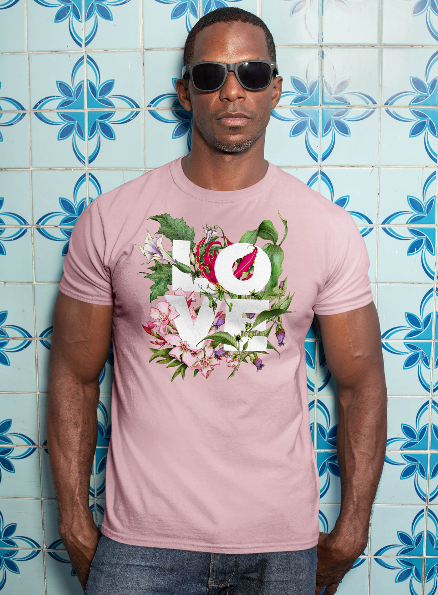 Female modeling a Pink unisex t-shirt featuring the word LOVE surrounded by poisonous flowers such as oleander, fire lily, belladonna and toloache.