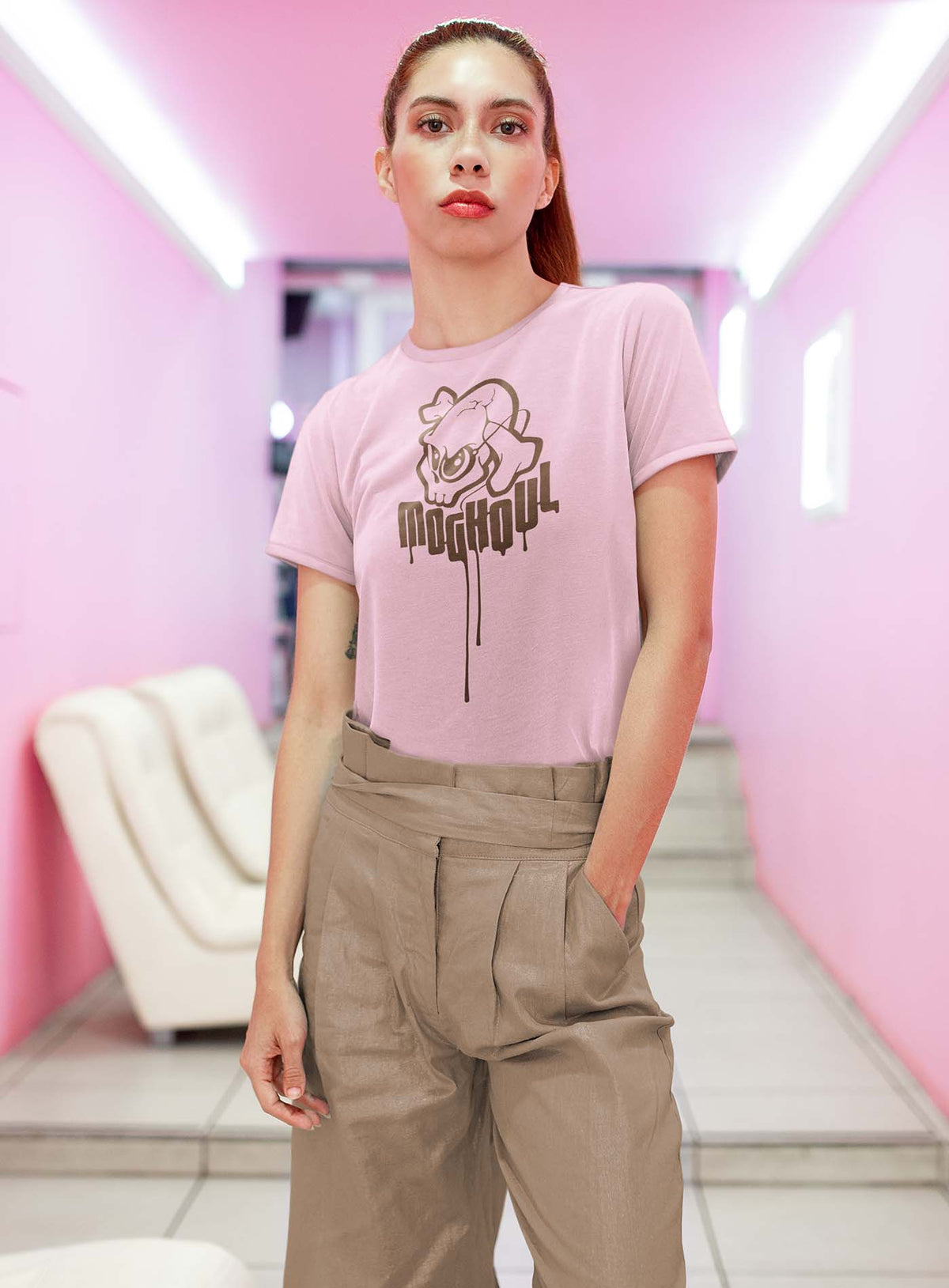 Female modeling a Pink unisex t-shirt featuring a yellow Mr. Shade Moghoul logo by G.M. Meave.