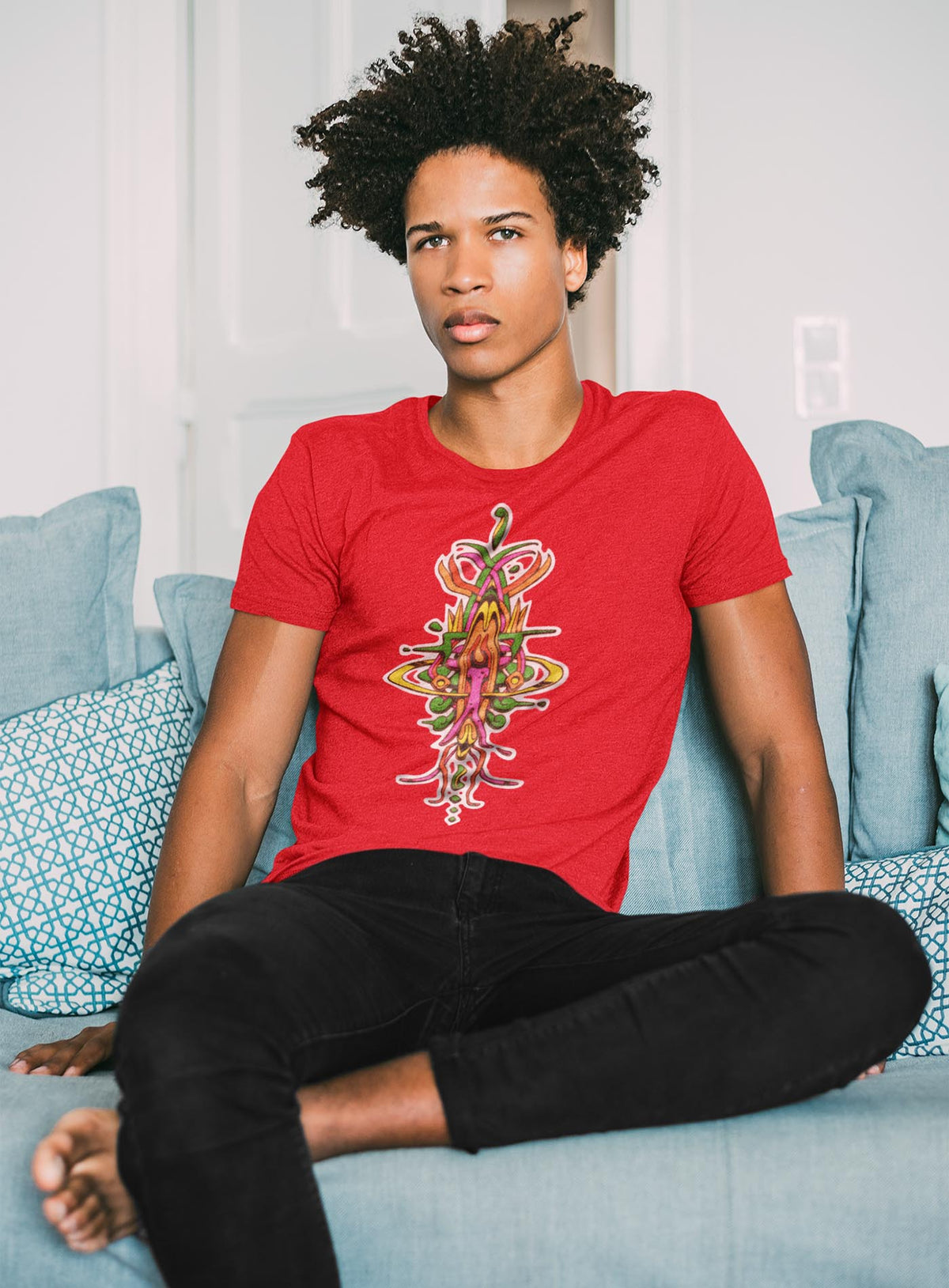man modeling a Heather red unisex t-shirt featuring a front print of the Toltec-Aztec hummingbird deity illustrated by G.M. Meave.