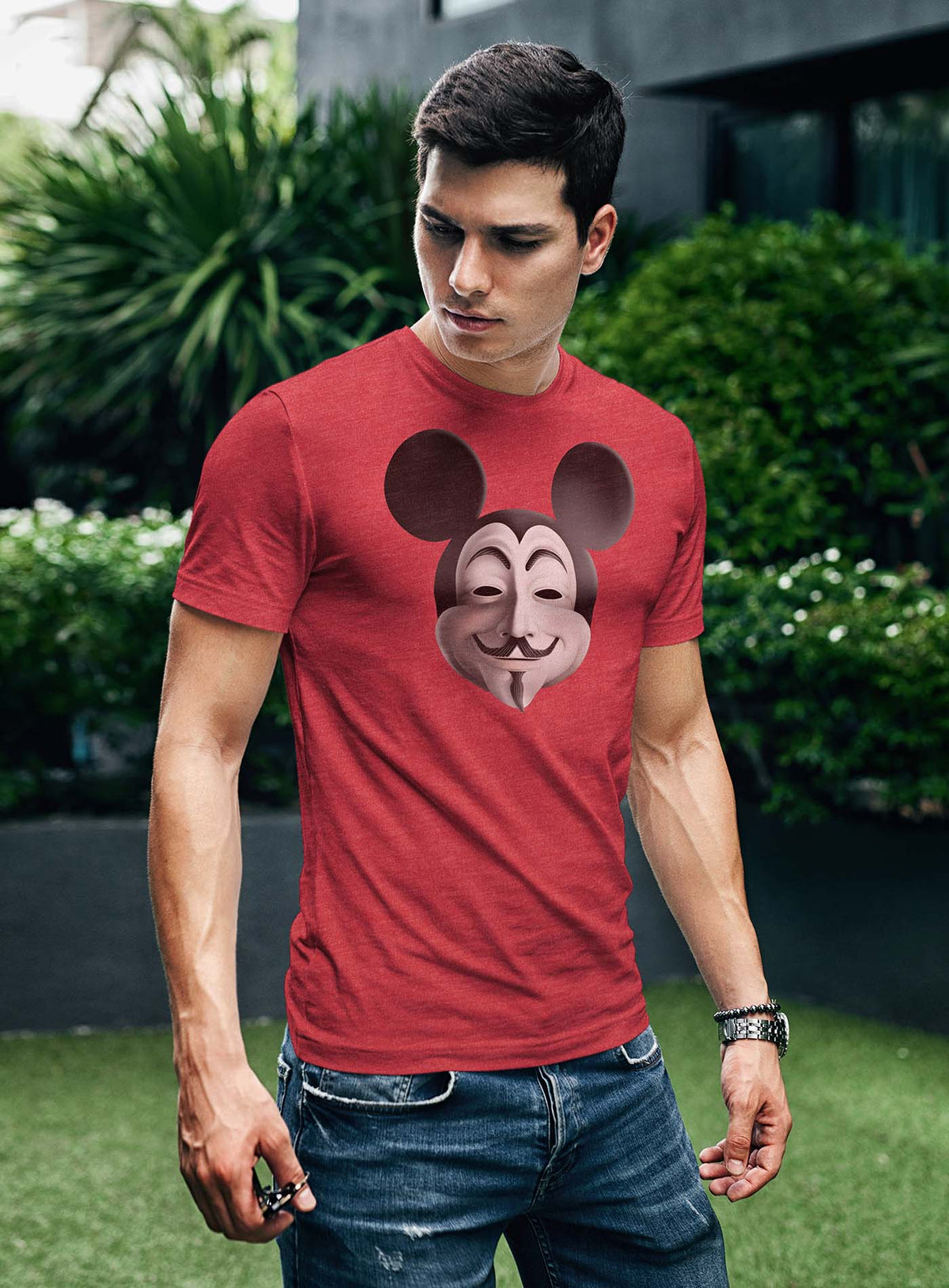 Man modeling a Heather red unisex t-shirt featuring a front print fusing Mickey Mouse and Guy Fawkes.