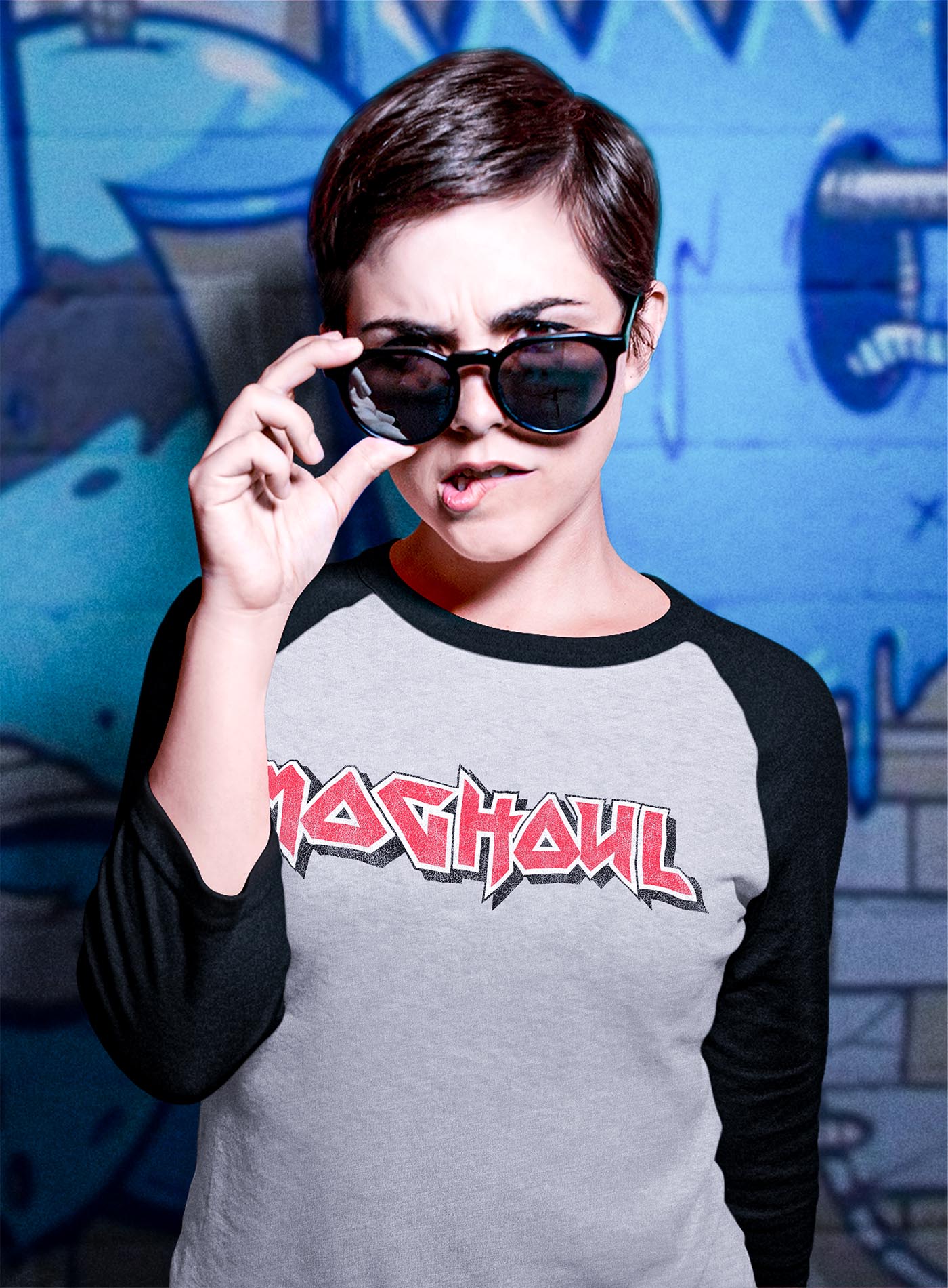 Female modeling a 3/4 sleeves raglan t-shirt featuring a front print of the Moghoul logo in vintage 80's hair-band style.